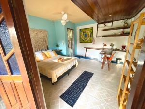 a bedroom with a bed and a table and a desk at Vila Entreluas in Morro de São Paulo