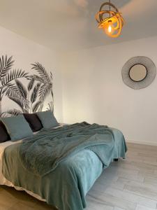 a bedroom with a bed with a plant on the wall at Le Toucan in Quessoy