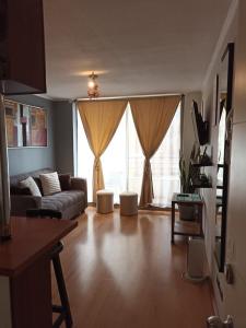 a living room with a couch and a large window at Recoleta Urban Suite in Santiago