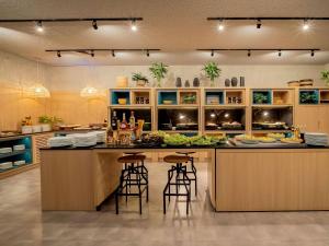 uma cozinha com uma grande ilha com bancos de bar em ibis Sao Paulo Paulista em São Paulo