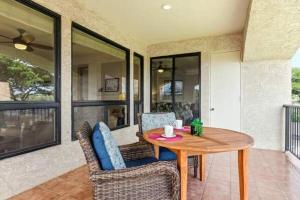 een tafel en stoelen in een kamer met een balkon bij Golf Course Townhome in Waikoloa Beach in Waikoloa