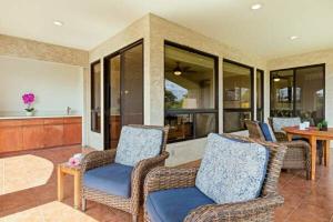 een woonkamer met twee stoelen en een tafel bij Golf Course Townhome in Waikoloa Beach in Waikoloa
