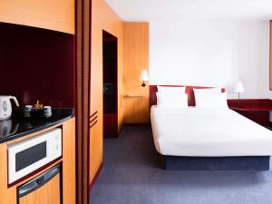 a hotel room with a bed and a microwave at Novotel Suites Hannover in Hannover