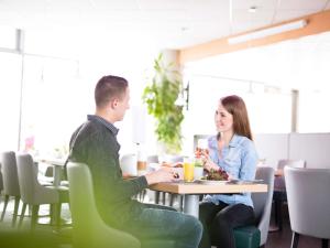 a man and woman sitting at a table in a restaurant at Novotel Suites Hannover in Hannover +36 photos