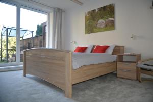 a bedroom with a wooden bed and a large window at Apartmán Alex, Nezábudka in Tatranska Strba +15 photos