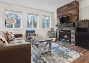 a living room with a couch and a fireplace at Mountain Gate - Pet Friendly 2BR w Mountain Views and open hot tub in Canmore