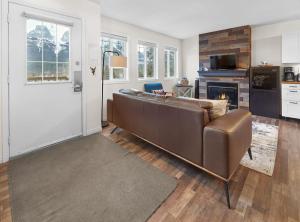 a living room with a brown couch and a fireplace at Mountain Gate - Pet Friendly 2BR w Mountain Views and open hot tub in Canmore