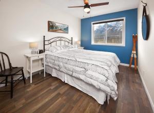 a bedroom with a bed and a desk and a window at Mountain Gate - Pet Friendly 2BR w Mountain Views and open hot tub in Canmore +17 photos