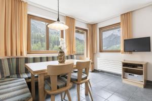 a dining room with a table and a tv at Chasa Vaidum by MEIN SAMNAUN - MOUNTAIN HOMES in Samnaun