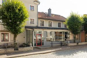 a building with glass doors on the side of a street at Home Hotel Majoren in Skövde