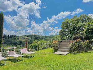 a garden with two chairs and a staircase with a view at V&E Luxury Villa in Arezzo