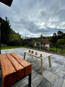 a wooden bench and a table on a patio at Chata pod Jabloňou in Banská Štiavnica