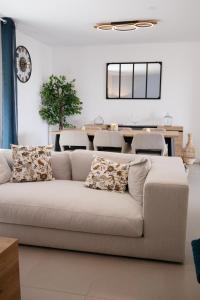 ein Wohnzimmer mit Sofa und Tisch in der Unterkunft Mon havre de paix, Villa Campagne Charentaise in Mansle