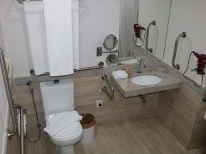 a bathroom with a toilet and a sink at Mercure Salvador Rio Vermelho in Salvador