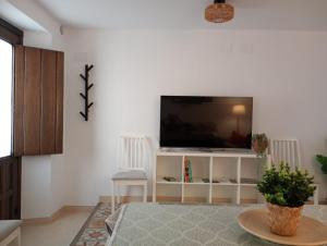 a living room with a flat screen tv on a wall at Alojamiento Rural Los Jarritos in Galaroza