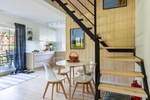 a kitchen and dining room with a table and chairs at Domek W Sosnach Poleski Park Narodowy in Grabniak