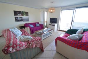 a living room with two couches and a tv at Laridae Getaway in Plettenberg Bay