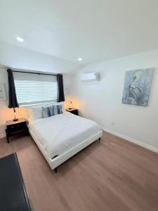 a white bedroom with a bed and a window at Amarillo Lodge in Simi Valley +26 photos