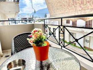 a vase with flowers on a glass table on a balcony at Casa Zoe in Igoumenitsa