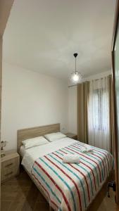 une chambre avec un lit avec une couverture rayée dans l'établissement Bujtina Halili Gjinar Two Bedrooms, à Gjinar 16 autres photos