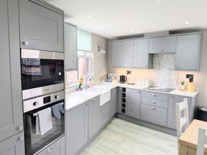 a white kitchen with white cabinets and appliances at Old Yarn Apartment - Close to city walls in York +8 photos