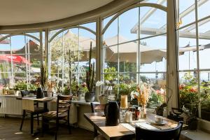 a restaurant with tables and chairs and windows at Hotel Kalenborner Höhe in Kalenborn