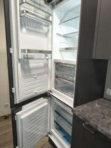 an empty refrigerator with its door open in a kitchen at Re-in City-DE in Regensburg
