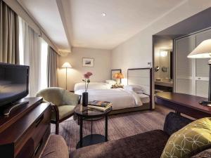 a hotel room with a bed and a television at The Cypress Mercure Hotel Nagoya in Nagoya