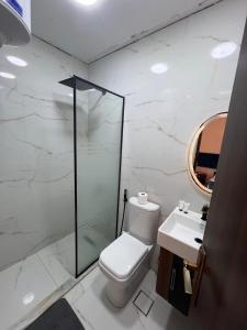 een witte badkamer met een toilet en een wastafel bij continital pyramids view in Caïro