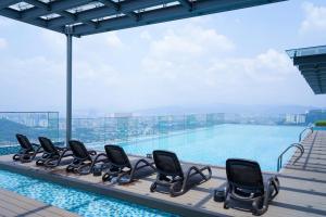 a row of chairs sitting next to a swimming pool at MLH Designer Duplex Suite @ EkoCheras in Cheras