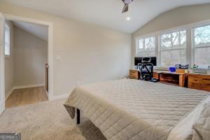 a bedroom with a bed and a desk and windows at Lakefront Getaway on Jackson Lake - 3BR-2BA-Hottub in Covington