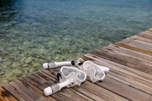 a pair of glasses sitting on a dock near the water at The Hacienda Beach Resort in Utila