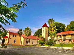 a building with palm trees in front of a street at Villa Deshaies in Deshaies