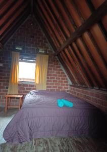 a bedroom with a bed in a brick wall at D'Bulan bungalows and kafe in Tetebatu