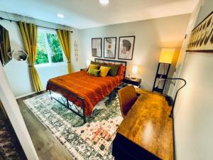 a bedroom with a bed and a couch and a table at Colorful Comfort 3 Bedroom Home with Fenced yard in Vancouver