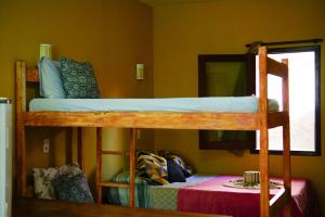 a bedroom with two bunk beds and a table at Barra Quintal - Studio 1 in Barra Grande