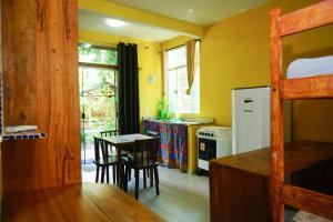a kitchen with a table and chairs and a refrigerator at Barra Quintal - Studio 1 in Barra Grande