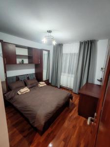 a bedroom with a large bed and a wooden floor at Apartament 2 camere decomandat! in Ploieşti