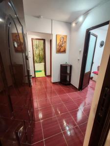a hallway with a red tile floor and a door at Apartament 2 camere decomandat! in Ploieşti +1 photo