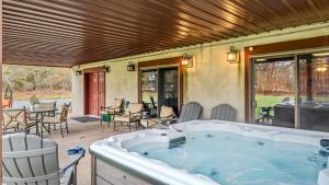 a hot tub on a patio with a table and chairs at Entertainers Home w Deck Game Room Hot Tub Lake View Retreat by AvantStay in Albrightsville