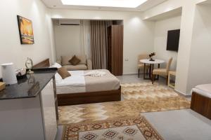 Una habitación de hotel con una cama y una sala de estar. en Arkan Hotel Qena, en Qinā