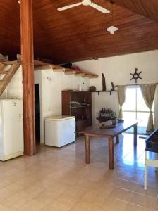 a kitchen with a wooden table and a refrigerator at Casa de playa Camping Chajarí in Santa Ana