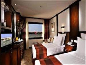 アスワンにあるNile Cruise FB 3 Nights Aswan Luxorの大きなベッドルーム(ベッド2台、大きな窓付)