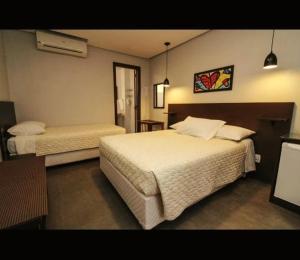 a hotel room with two beds in a room at Pousada Araucárias in Canela