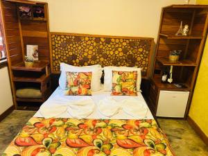 a bedroom with a bed with a bedspread with fruits on it at Sanctuary Pirenópolis Suítes e Flats in Pirenópolis