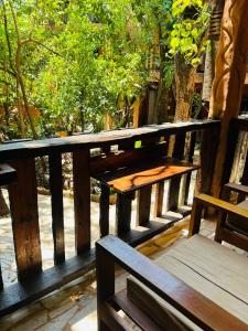 a wooden bench sitting on a wooden deck with trees at Sanctuary Pirenópolis Suítes e Flats in Pirenópolis +158 photos