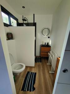 a bathroom with a toilet and a door in a room at Ataoaoa iti Bungalow à Punaauia in Punaauia