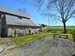 eine Scheune aus Stein mit einem Tisch und Bänken davor in der Unterkunft 1 Bed in Knighton 58997 in Whitton