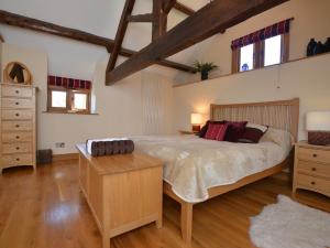 ein großes Schlafzimmer mit einem großen Bett und Holzböden in der Unterkunft 1 Bed in Knighton 58997 in Whitton