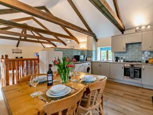a kitchen and dining room with a wooden table and chairs at 2 Bed in Portreath OLDMM in Camborne